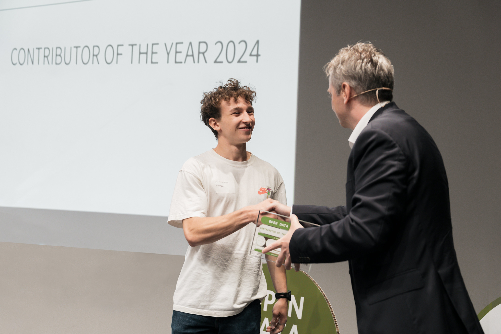 Henri Egger and Patrick Ohnewein shaking hands during the Contributor of the Year award ceremony at Open Data Hub.