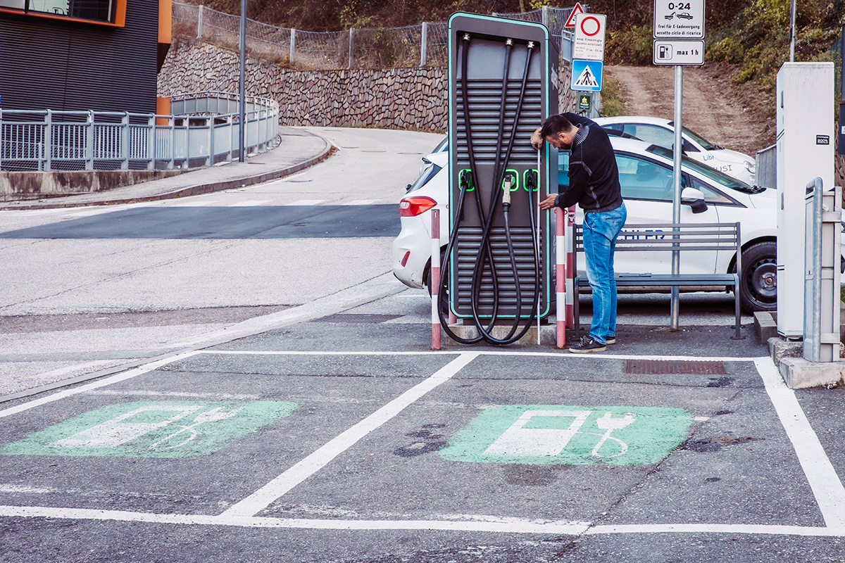 Independent L staff inspecting an EV charging station to evaluate accessibility for people with disabilities in South Tyrol.