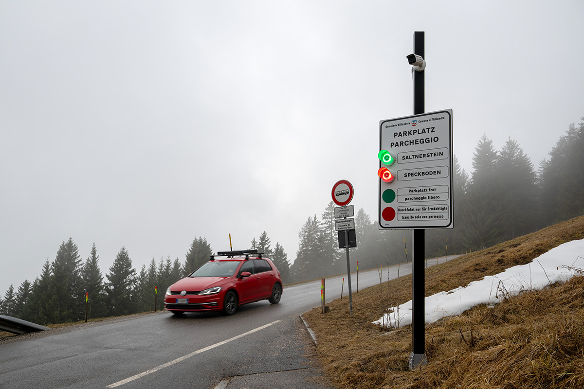 Roadside smart parking information sign with an AI-powered monitoring camera providing real-time parking availability.