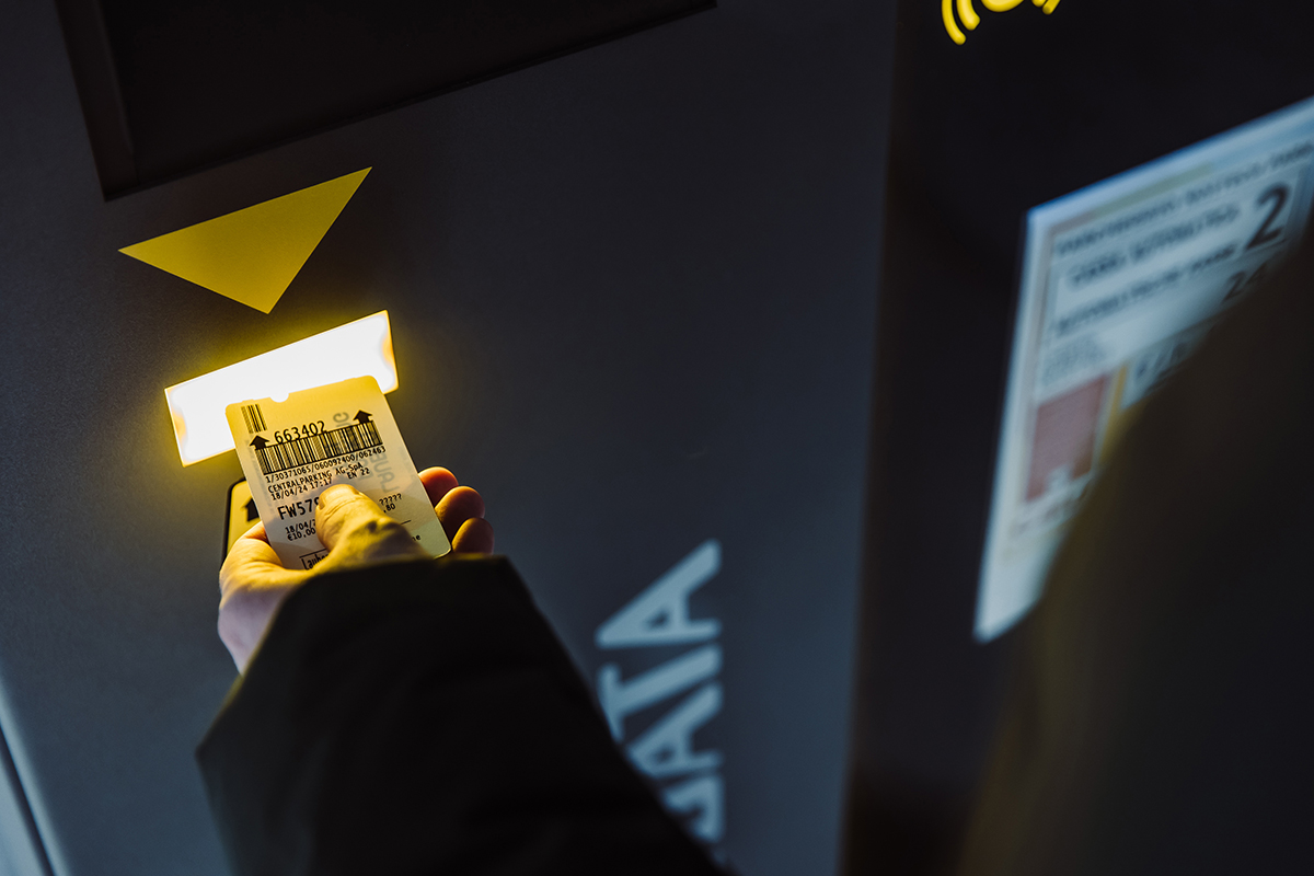 Hand scanning a SKIDATA parking ticket, part of integration that shares real-time parking data with Open Data Hub.