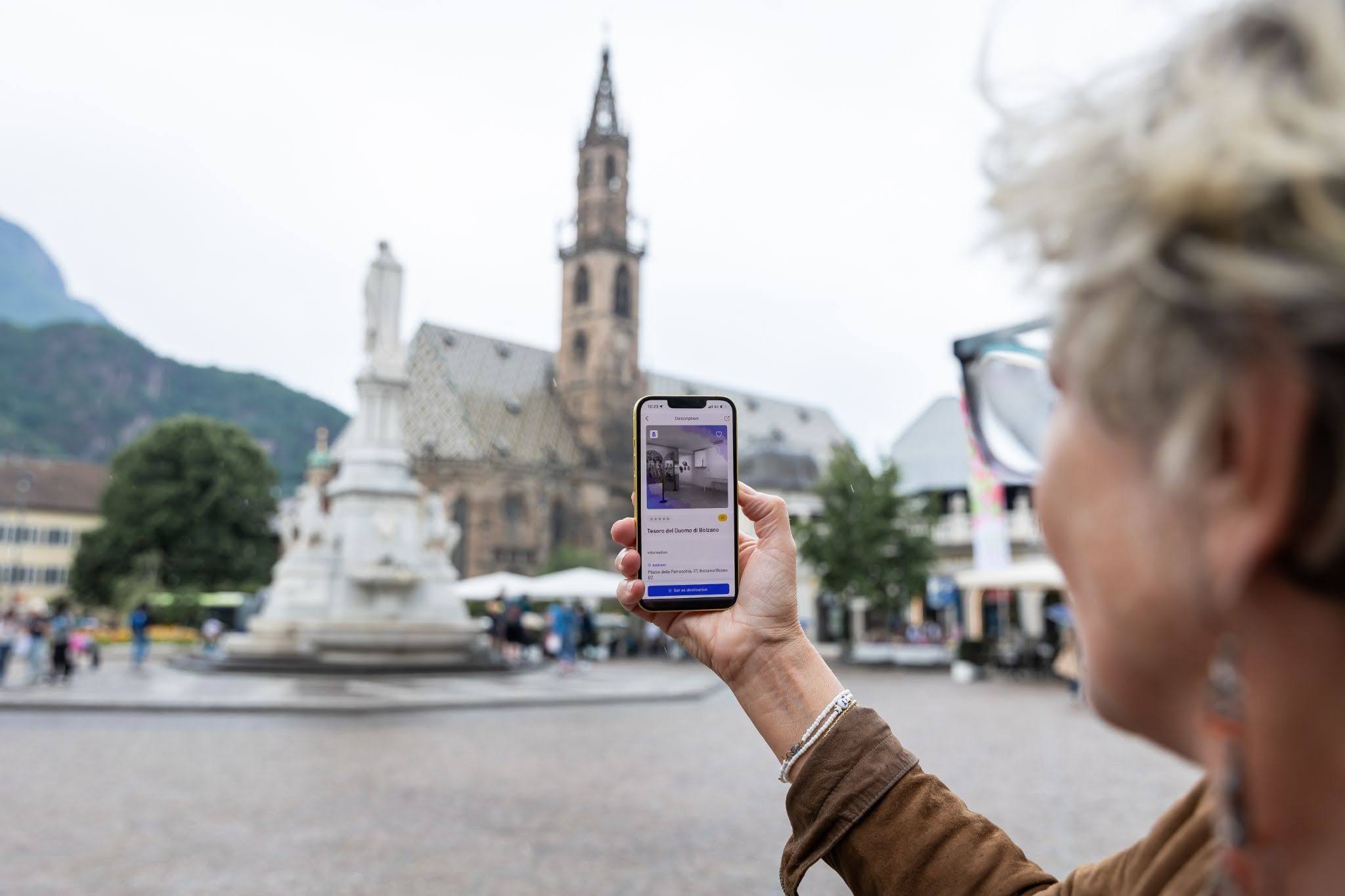 User using Stendhapp in an urban square, illustrating Open Data Hub Data Access for tourism and culture applications.